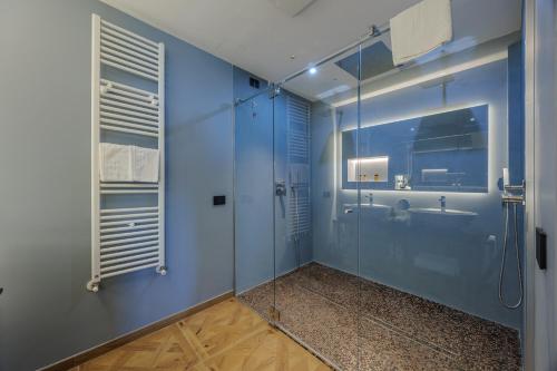 a blue bathroom with a shower and a sink at Deville & Spa in Costermano sul Garda