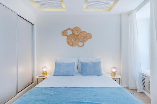 a bedroom with a large bed with blue pillows at The 23 Suites in Faro