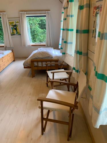a room with two beds and two chairs at Casita amarilla in Helsinge
