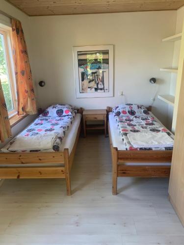 two twin beds in a room with a window at Casita amarilla in Helsinge