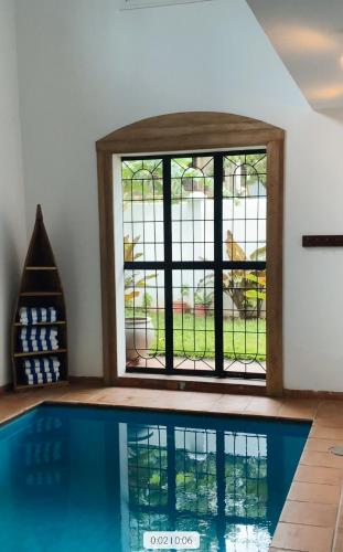 a swimming pool with a window in a room at Sunny Shore B&B in Dar es Salaam