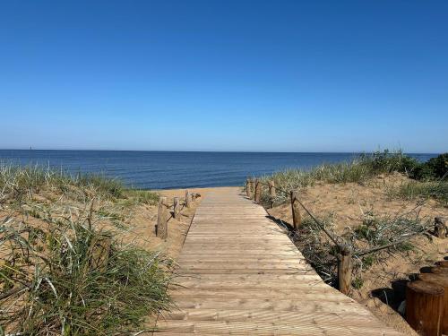 a wooden path to the beach with the ocean at Villa Gāles Hotel in Saulkrasti