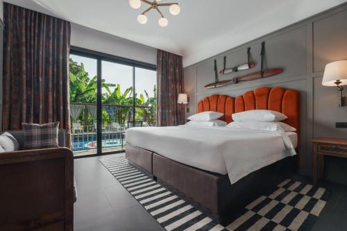 a bedroom with a large bed and a balcony at Sugar Marina Hotel -AVIATOR- Phuket Airport in Nai Yang Beach