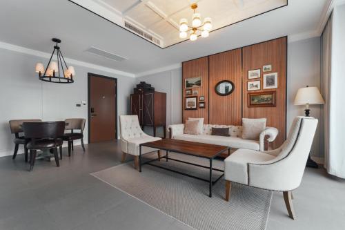 a living room with a couch and a table and chairs at Sugar Marina Hotel -AVIATOR- Phuket Airport in Nai Yang Beach