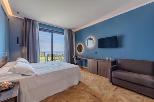 a bedroom with a bed and a chair and a television at Deville & Spa in Costermano sul Garda