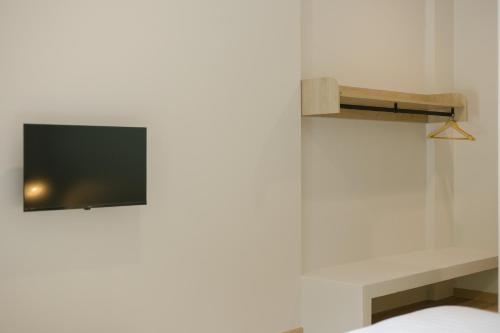a tv on a wall in a room with a bed at My Hotel Kanchanaburi in Ban Chuk Kum