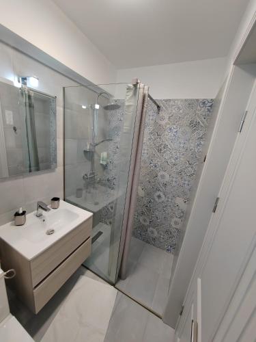 a white bathroom with a shower and a sink at Casa BEYAZ in Mangalia