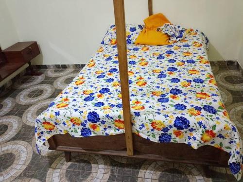 a bed with a floral comforter in a room at Quiet and Secure House, Hohoe in Hohoe