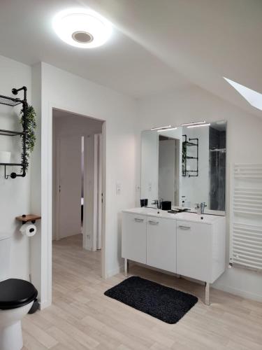 a white bathroom with a sink and a mirror at Maison 3 chambres in Trignac