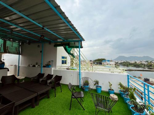 乌代浦Turtle Hostel Udaipur的阳台上配有桌椅的露台