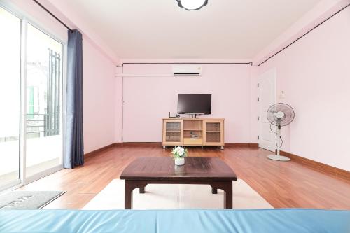 a living room with a table and a tv at The Comfort house near CMU in Chiang Mai