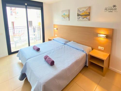 sypialnia z 2 łóżkami i fioletowymi poduszkami w obiekcie Yasumi Suite - 4p Modern Apartment with Parking & Swimming Pool w Lloret de Mar