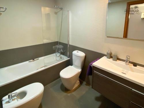 łazienka z toaletą, umywalką i lustrem w obiekcie Yasumi Suite - 4p Modern Apartment with Parking & Swimming Pool w Lloret de Mar