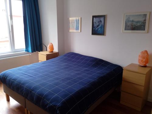 a bedroom with a blue comforter on a bed at Luxurious 2 bedroom appartment in Antwerp
