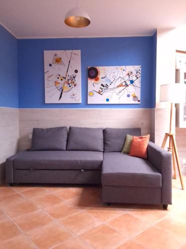 a couch in a living room with paintings on the wall at SantuMasi Bed & Breakfast in Gallipoli