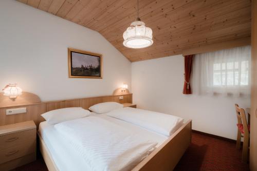 a bedroom with a large white bed in it at Appartmenthotel Residence Elvis in Ortisei