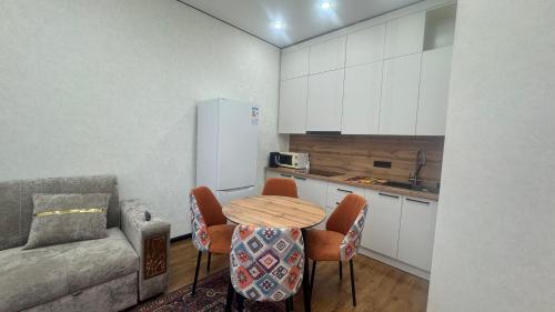 a kitchen with a table and chairs and a couch at Landmark in Astana