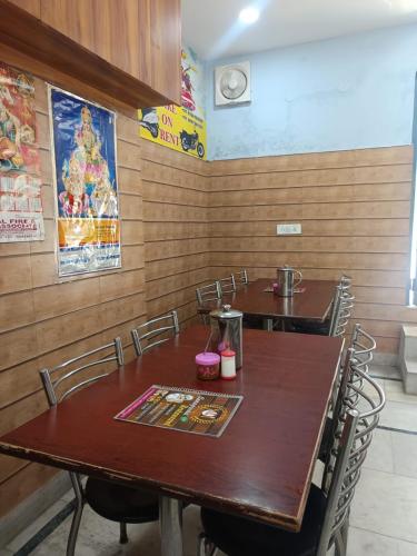 uma sala de jantar com duas mesas e cadeiras em Hanumant Resort em Dehradun