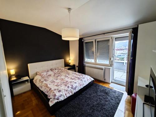Un dormitorio con una cama y una ventana grande. en Sunny River BL, en Banja Luka