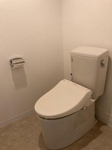 a bathroom with a white toilet in a room at J-Hoppers Beppu Guesthouse ジェイホッパーズ別府ゲストハウス in Beppu