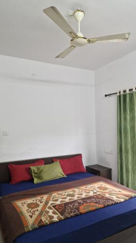a bedroom with a bed with a ceiling fan at Mirth by Windy County in Vagamon