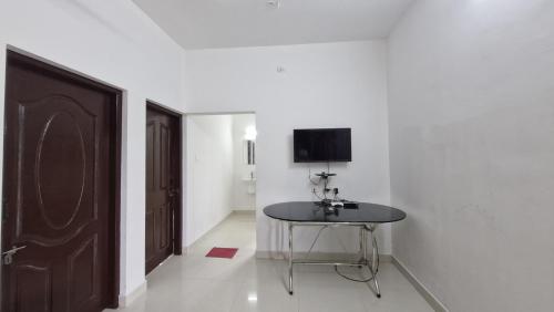 a room with a table and a tv on a wall at Mirth by Windy County in Vagamon