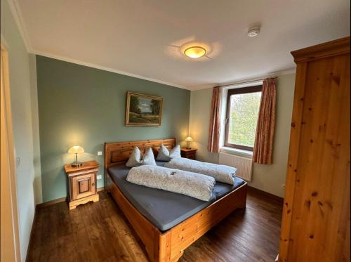 a bedroom with a bed with two pillows on it at LandHotel Lönskrug in Hellental