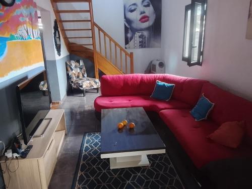 a living room with a red couch and a table at Villa des Filaos et du lagon o6, 93 , 70 , 59 , 79 in Saint-Leu