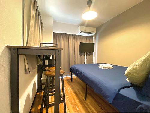 a small bedroom with a bed and a desk at HUJI Shinjuku House in Tokyo