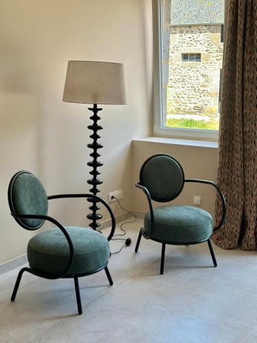 two chairs and a lamp in a room at La Maison Gervaiserie & Spa in Réville