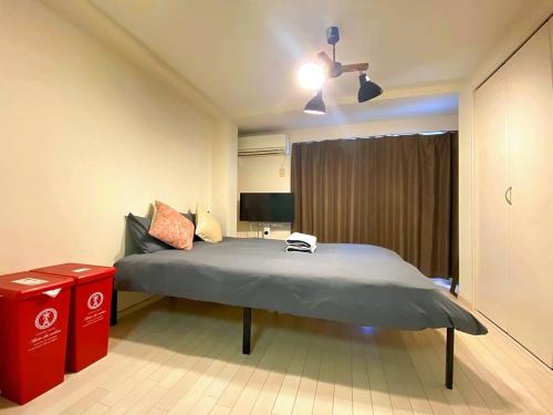a bedroom with a bed with a ceiling fan at Liberty Shinjuku House in Tokyo