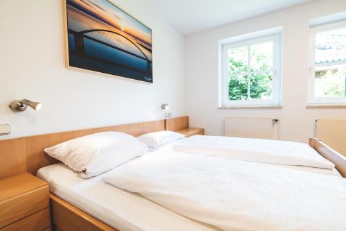2 camas blancas en una habitación con 2 ventanas en Binnenseeblick, en Fehmarn