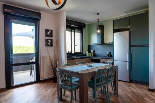 eine Küche mit Tisch und Stühlen und einem Kühlschrank in der Unterkunft Terrazza Teodorico in Ravenna