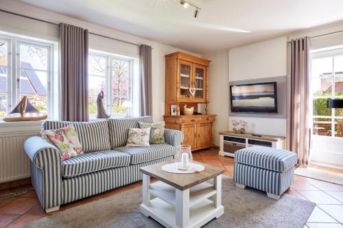 a living room with a couch and a tv at Annes Cottage 2 in Oevenum