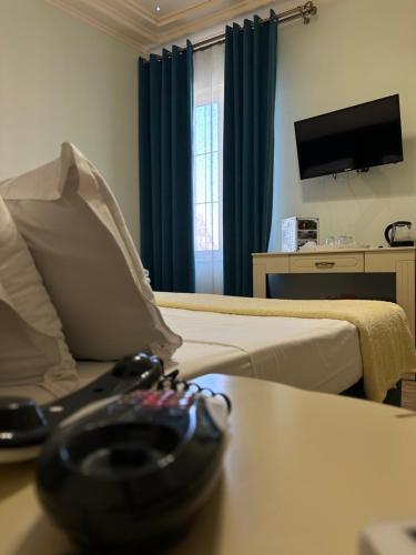 a hotel room with a bed and a table with a bowl on it at Hotel Veliera in Durrës