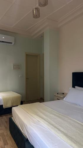 a bedroom with two beds and a door to a closet at Hotel Veliera in Durrës