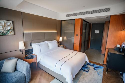 a bedroom with a large white bed and a couch at Value Comfort Hotel Guangzhou in Guangzhou