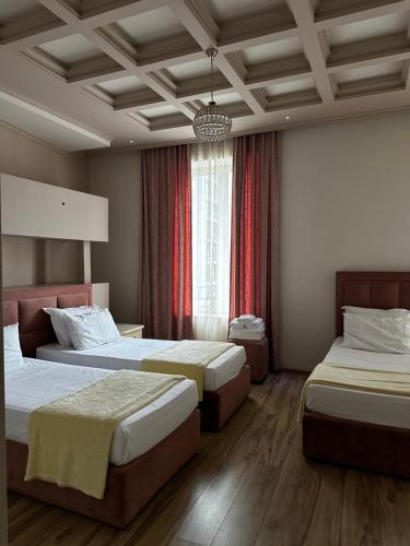 a hotel room with two beds and a window at Hotel Veliera in Durrës