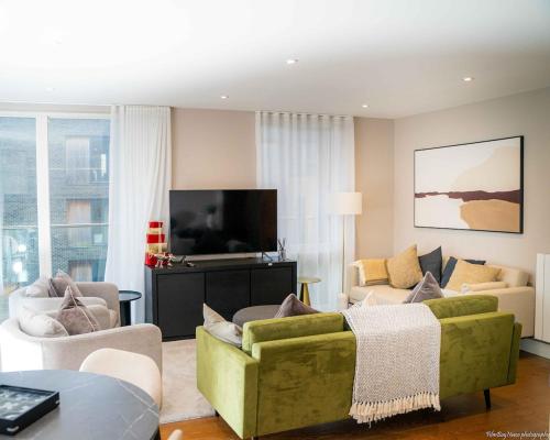 a living room with a green couch and a tv at A home away from home! in London