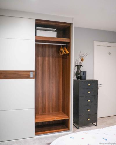 a closet with a wooden door and a dresser at A home away from home! in London