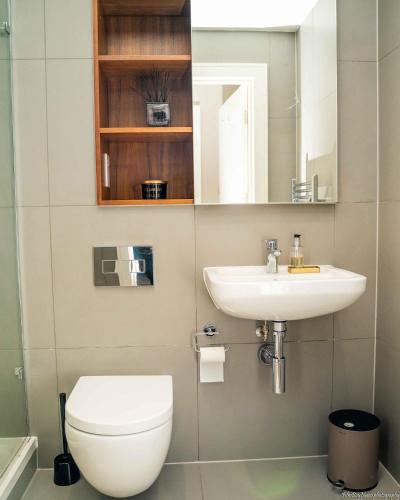 a bathroom with a toilet and a sink at A home away from home! in London