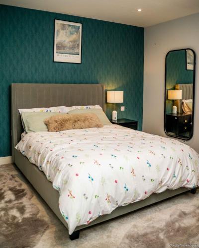 a large bed in a bedroom with green walls at A home away from home! in London
