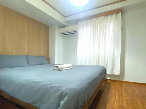 a bedroom with a large bed with a window at Ema eve HOUSE in Tokyo
