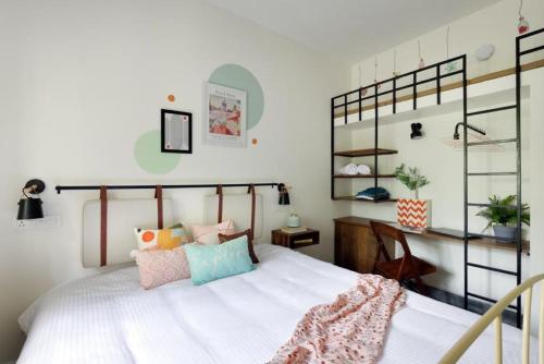 a bedroom with a large white bed with pillows at Blissful Stay, LUX Suites & Tint of Mint - 1 BHK Apartment, 5min Beach, Auroville Pondicherry in Kottakupam