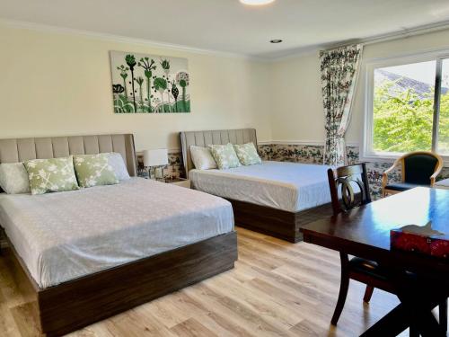 a bedroom with two beds and a table and a desk at Master Bedroom with Two Queen Sized Bed in Richmond