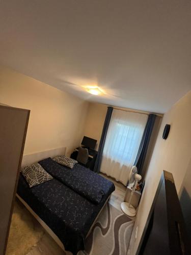 a small bedroom with a bed and a window at Apartament 3 camere Untold 7-11Aug in Floreşti