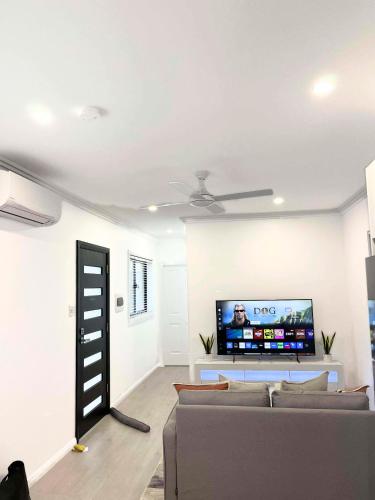 a living room with a couch and a flat screen tv at 2 Bedrooms Minimalist Home in Moss Vale in Moss Vale