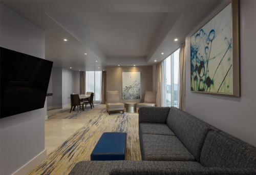 a living room with a couch and a tv at Hilton Panama in Panama City