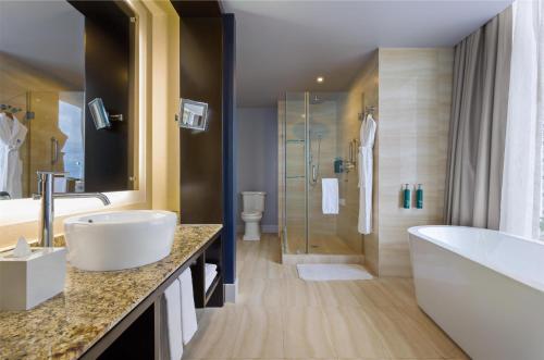 a bathroom with a tub and a sink and a shower at Hilton Panama in Panama City