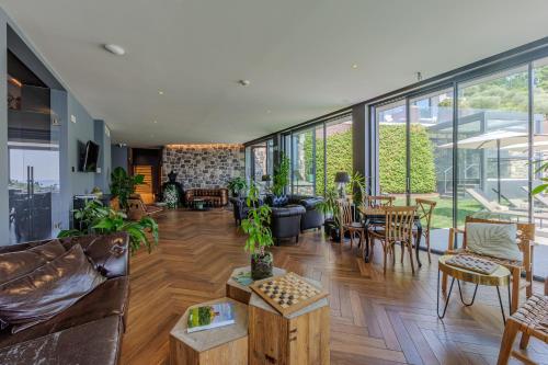a living room filled with lots of furniture and plants at Deville & Spa in Costermano sul Garda